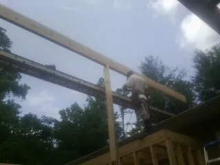 Carpenter setting a ridge beam over a new addition frame — Ice Dam Removal by Roofing Brothers in Alpharetta