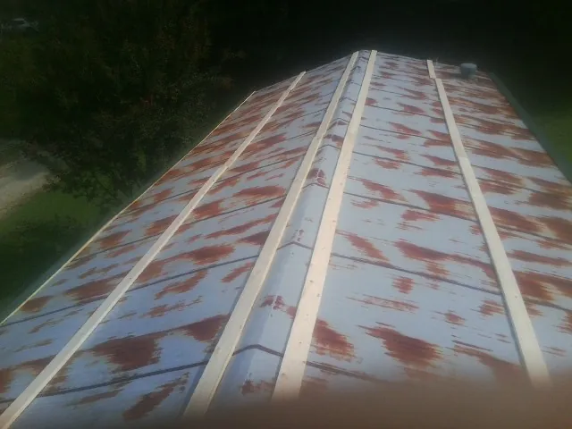 Rusted metal roof panels with new wood purlins before replacement — Storm Damage Roof Repair in Alpharetta by Roofing Brothers