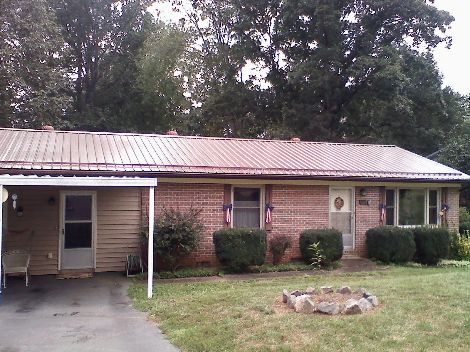 Bronze metal roof and carport on a brick ranch home — Roof Repair work by our crew in Alpharetta