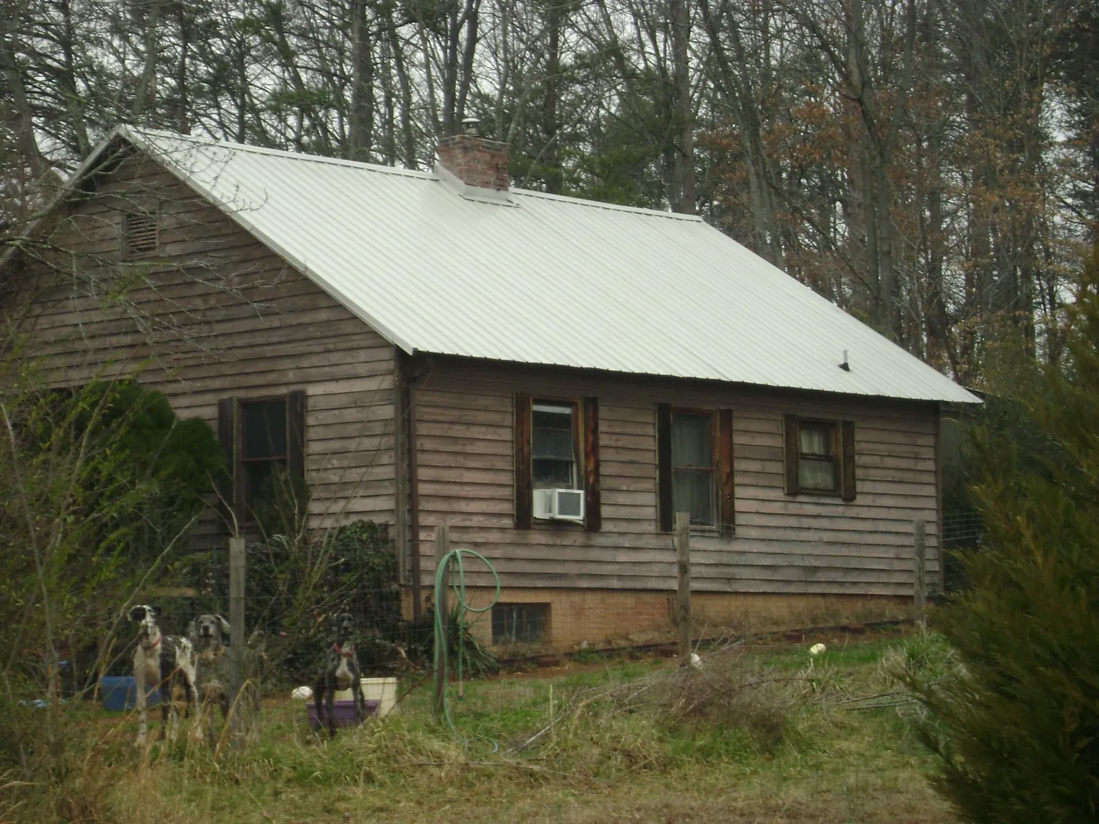 White metal roof on an old wood sided farmhouse, from a Metal Roof Installation job in Alpharetta